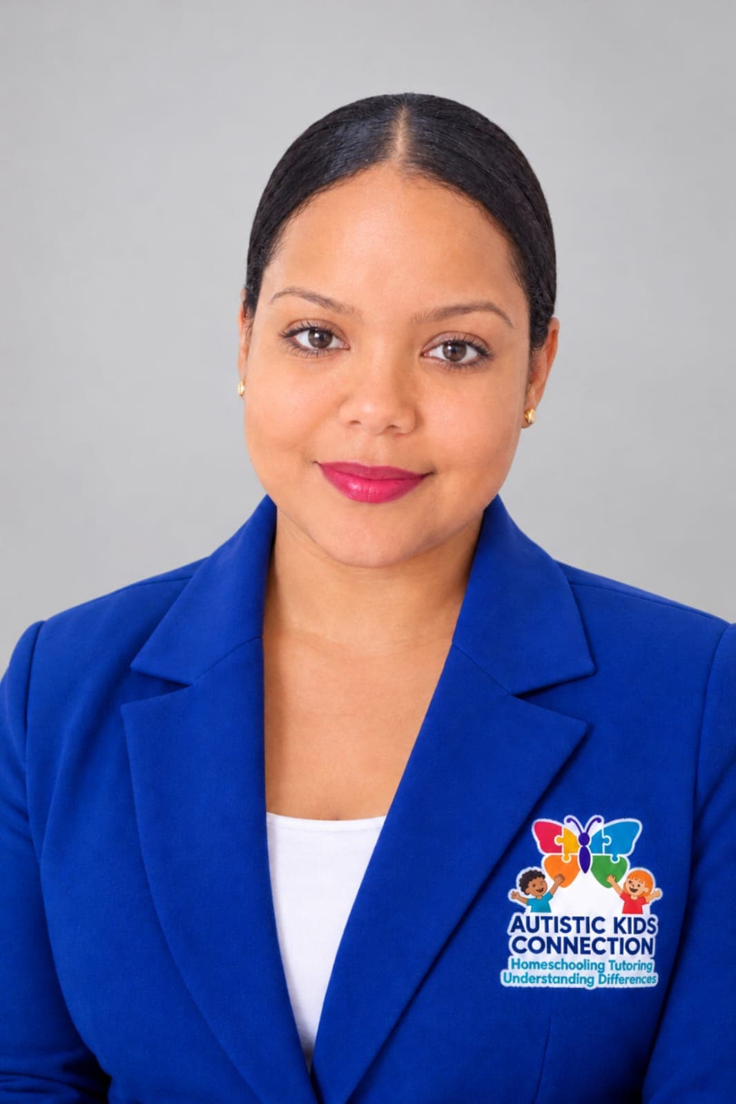 Jameela Khan, wearing a blue blazer with the Autistic Kids Connection logo